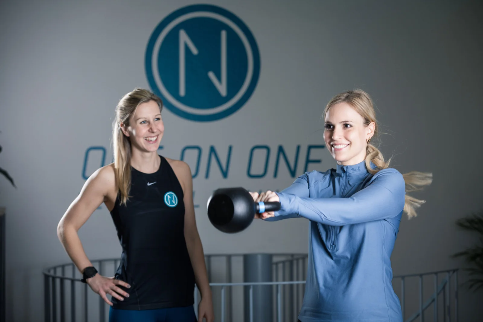 Trainerin begleitet eine Frau beim Kettlebell-Krafttraining im Ladies Gym