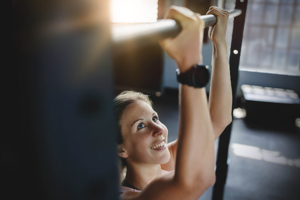 Teilnehmerin beim Krafttraining an der Klimmzugstange im 1on1 Studio